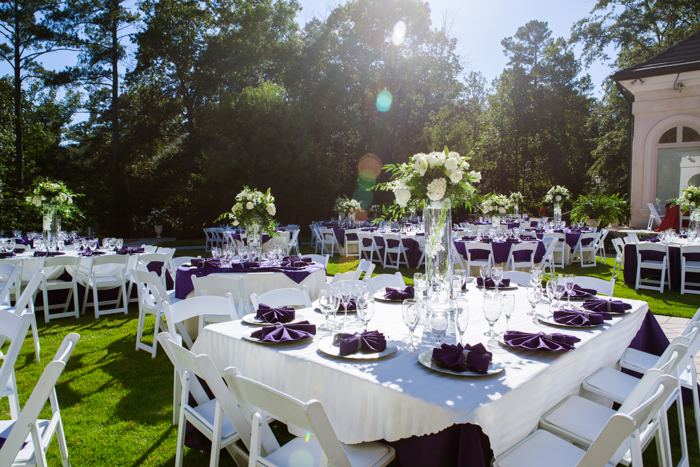 Garden reception tables set beneath tall trees