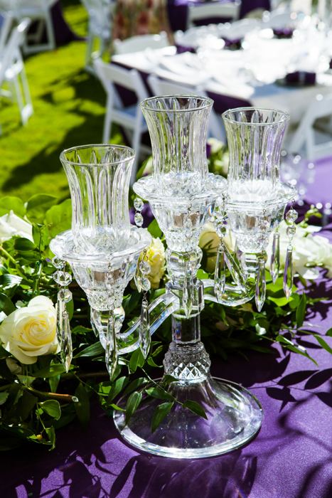 Crystal candlestick and glassware on a purple tablecloth