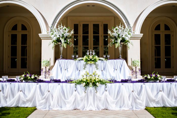 Head table framed by arched columns and white flowers