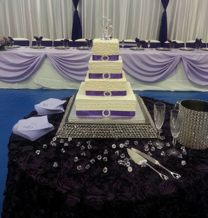 Tiered wedding cake on a sparkling purple tablecloth